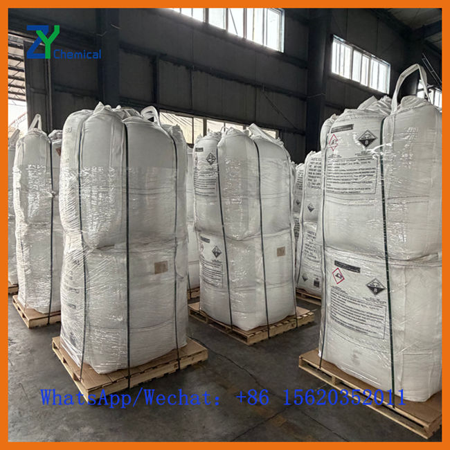 Grand sac Jumbo (Big Bag) de 1000 kg rempli de soude caustique perlée dans un entrepôt logistique B2B.